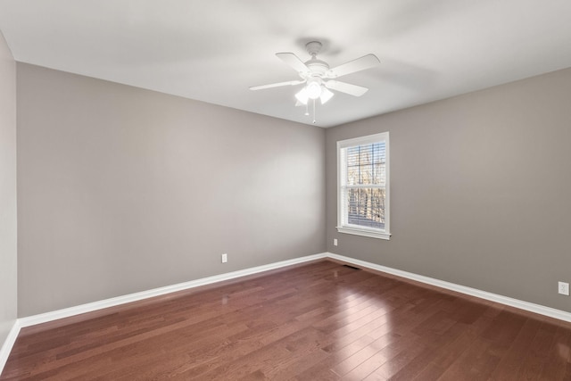 empty room featuring ceiling fan and dark wood-type flooring