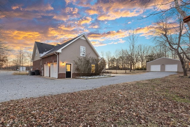 property exterior at dusk with central air condition unit and a garage