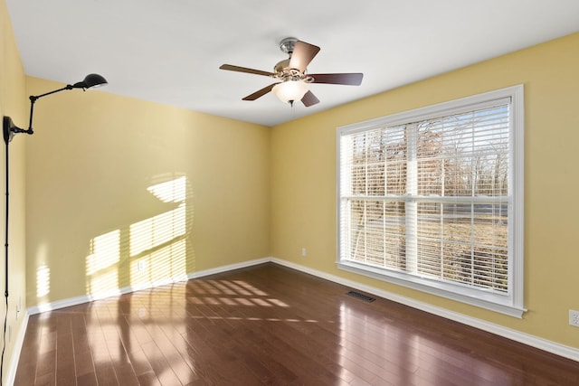 unfurnished room with dark wood-type flooring and ceiling fan