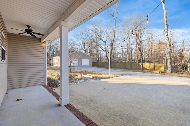 view of patio with ceiling fan, a garage, and an outdoor structure