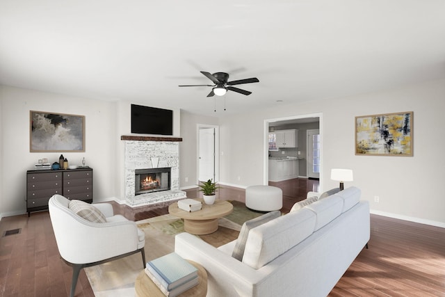 living room featuring ceiling fan and dark hardwood / wood-style floors