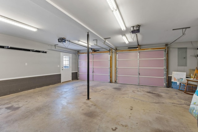 garage with a garage door opener and electric panel