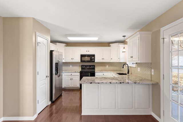 kitchen featuring kitchen peninsula, hanging light fixtures, sink, stainless steel fridge with ice dispenser, and range with electric cooktop