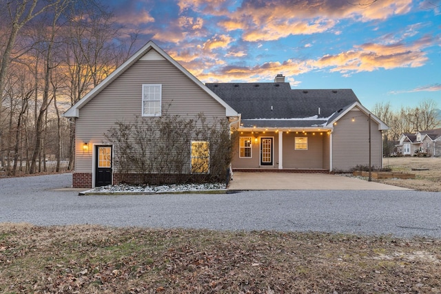 back house at dusk with a patio area