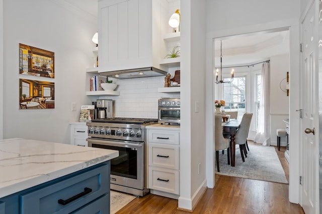 kitchen with light hardwood / wood-style flooring, premium range hood, white cabinetry, light stone countertops, and stainless steel range