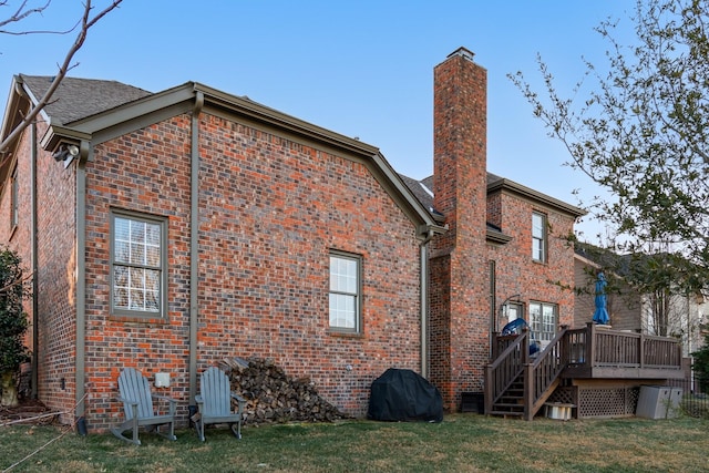 rear view of property with a deck and a yard