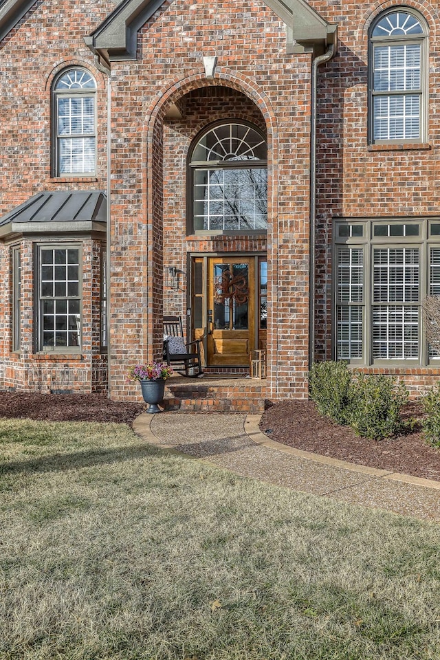 view of exterior entry with a yard