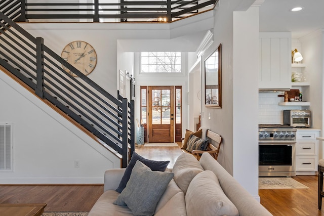 foyer entrance with light wood-type flooring and a towering ceiling