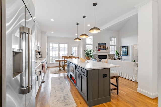 kitchen featuring a kitchen breakfast bar, pendant lighting, white cabinets, gray cabinetry, and a kitchen island