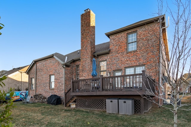 back of property featuring a lawn and a deck