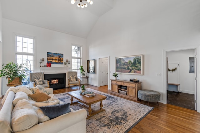 living room featuring electric panel, high vaulted ceiling, and hardwood / wood-style floors