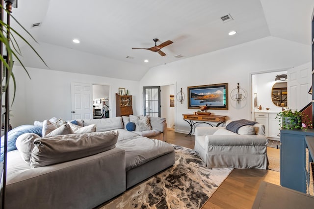 living room with ceiling fan, lofted ceiling, and light wood-type flooring