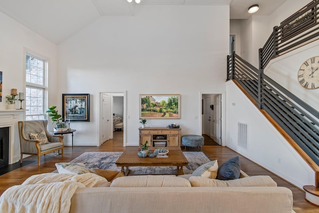 living room with wood-type flooring and high vaulted ceiling