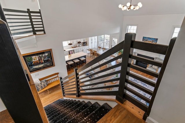 staircase featuring wood-type flooring and a chandelier