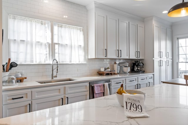 kitchen featuring sink, hanging light fixtures, stainless steel dishwasher, and tasteful backsplash