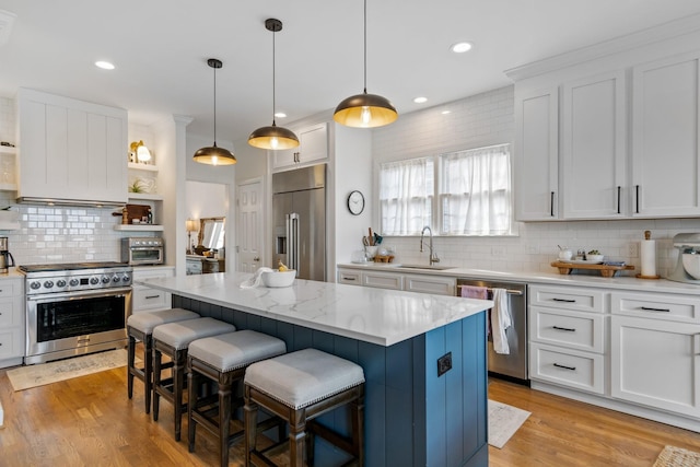 kitchen featuring a kitchen island, backsplash, high end appliances, and white cabinetry