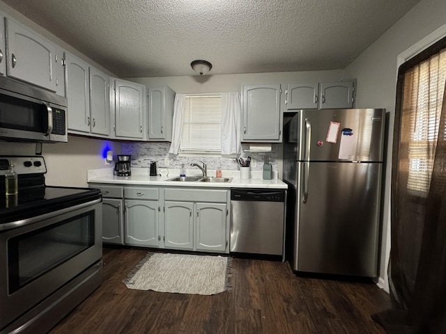 kitchen featuring sink, a textured ceiling, dark hardwood / wood-style floors, and stainless steel appliances