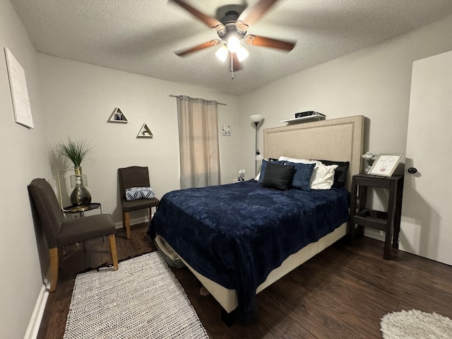 bedroom with ceiling fan, dark wood-type flooring, and a textured ceiling