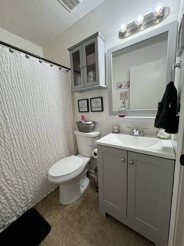 bathroom with toilet, a textured ceiling, curtained shower, and vanity