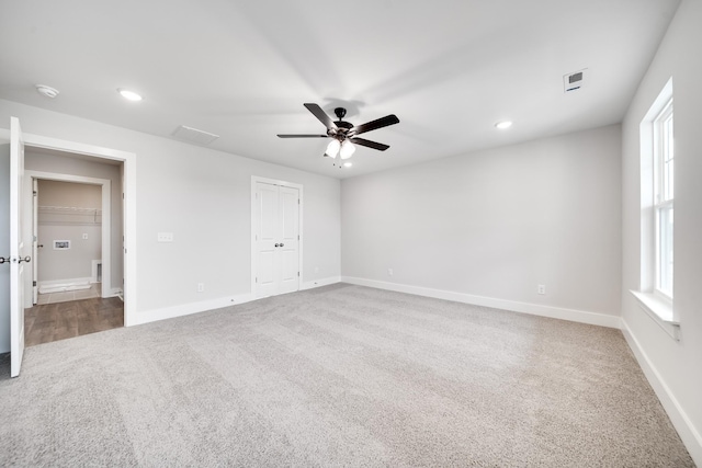 carpeted spare room with a healthy amount of sunlight and ceiling fan