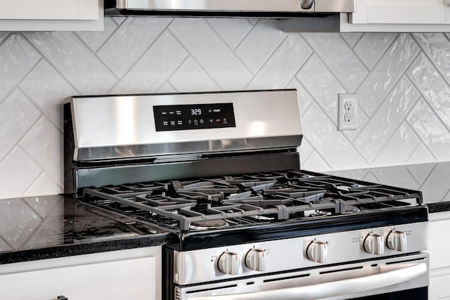 details featuring white cabinetry, decorative backsplash, and stainless steel range with gas cooktop