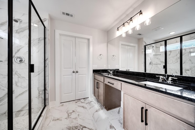 bathroom with a shower with door and vanity