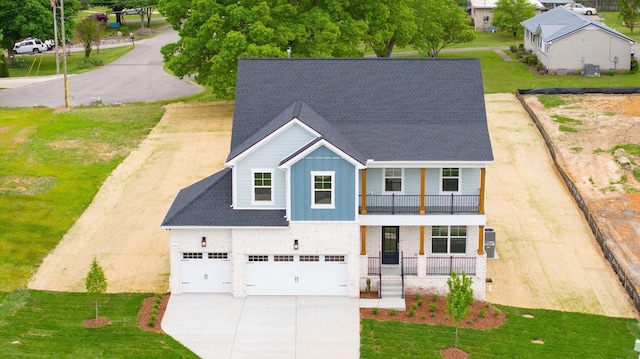 view of front of home with covered porch, cooling unit, a balcony, and a garage