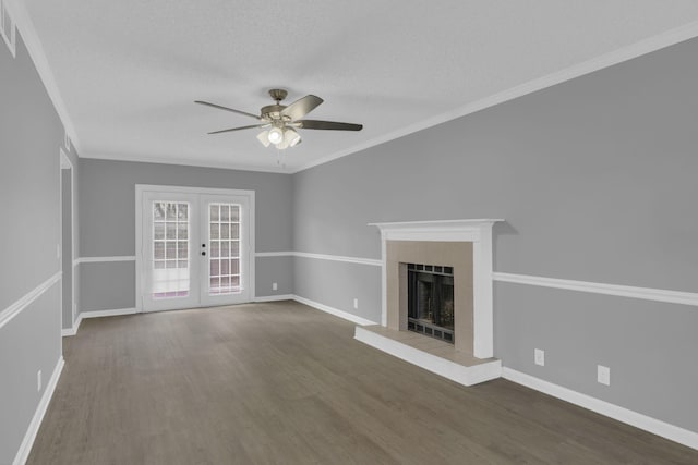 unfurnished living room with french doors, dark wood-type flooring, a fireplace, a textured ceiling, and ornamental molding