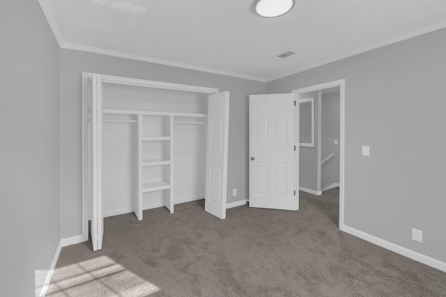 unfurnished bedroom with a closet, carpet, ornamental molding, and a textured ceiling