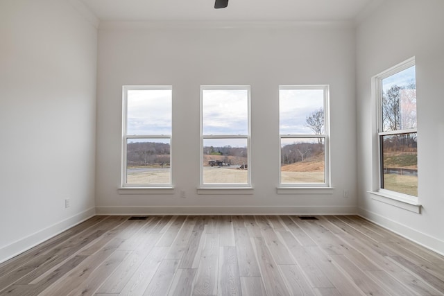 empty room featuring ceiling fan, crown molding, and light hardwood / wood-style floors