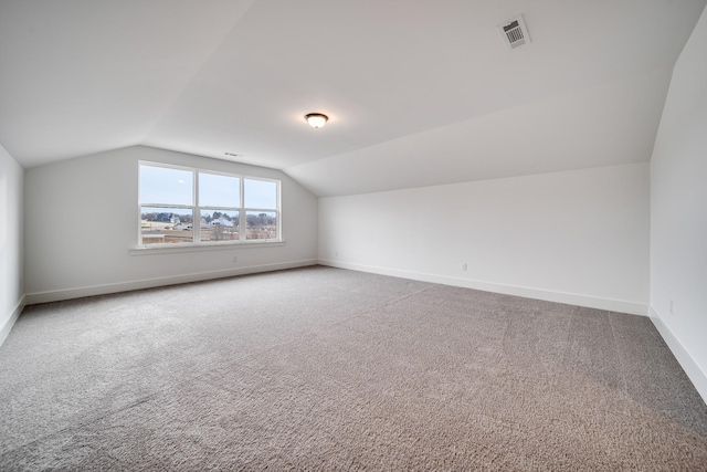 additional living space featuring vaulted ceiling and carpet floors