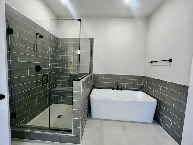 bathroom featuring tile walls, tile patterned floors, and shower with separate bathtub