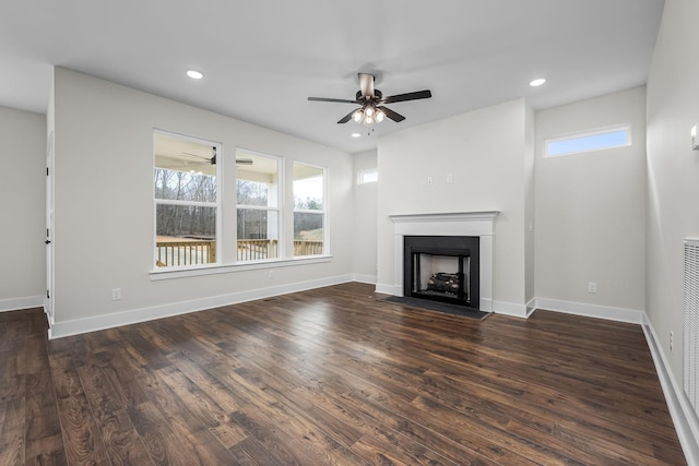 unfurnished living room featuring ceiling fan, dark wood-type flooring, and a healthy amount of sunlight