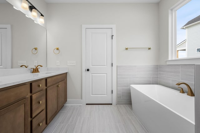 bathroom featuring vanity, a bathtub, and tile walls