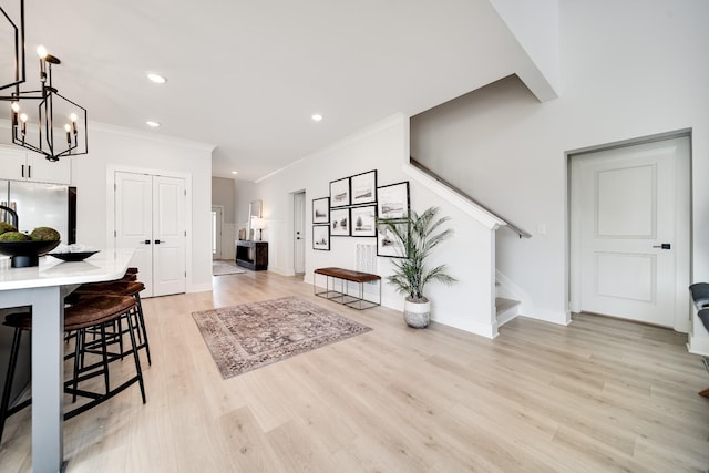 foyer entrance with crown molding and light hardwood / wood-style floors