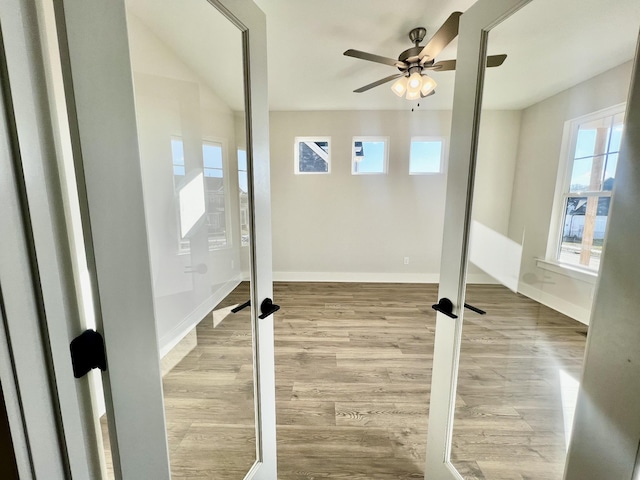 exercise area with a wealth of natural light, light hardwood / wood-style floors, and ceiling fan