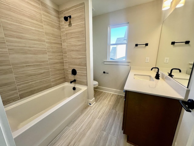 full bathroom with tiled shower / bath, vanity, and toilet