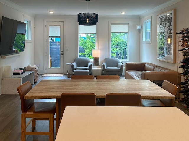 dining area featuring a notable chandelier, hardwood / wood-style flooring, and crown molding