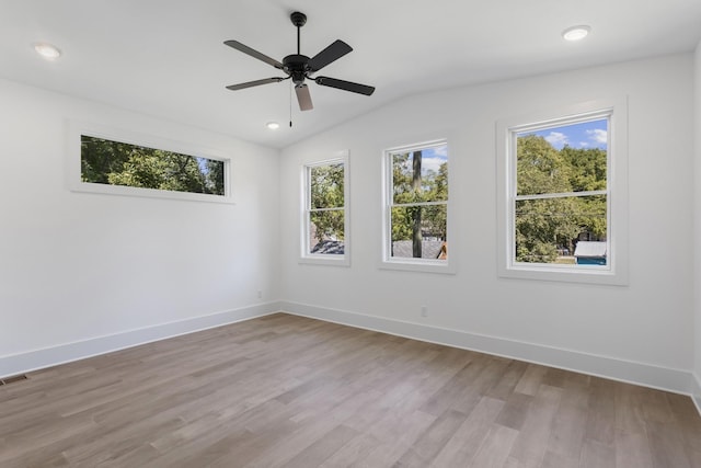 empty room with ceiling fan, light hardwood / wood-style flooring, and lofted ceiling