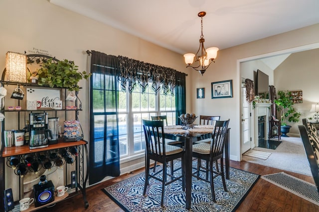 dining room featuring a healthy amount of sunlight, an inviting chandelier, and dark wood-type flooring