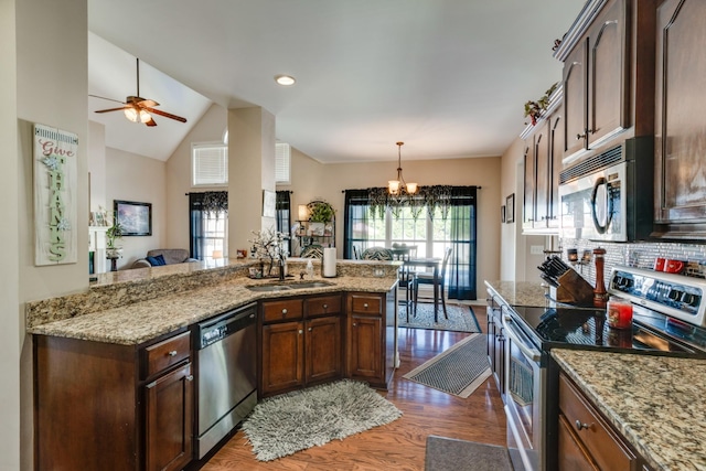 kitchen featuring sink, light stone countertops, appliances with stainless steel finishes, and dark wood-type flooring