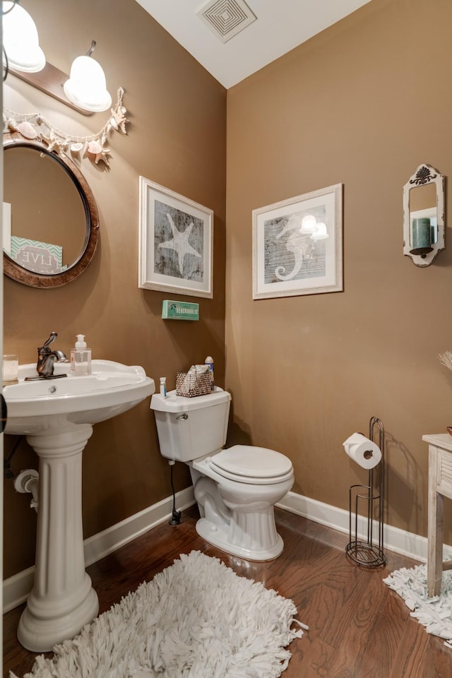 bathroom featuring hardwood / wood-style flooring and toilet