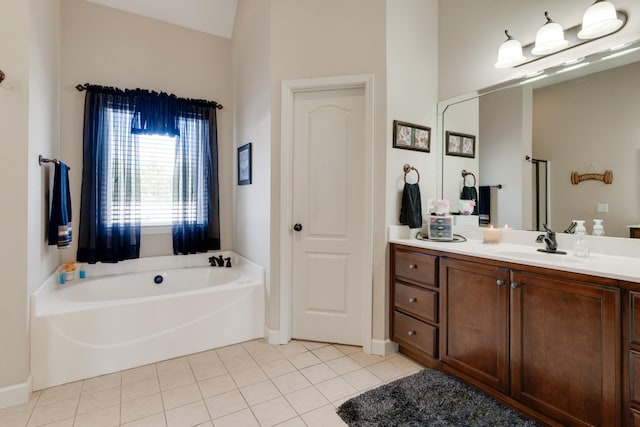 bathroom with a tub to relax in, vanity, and tile patterned flooring