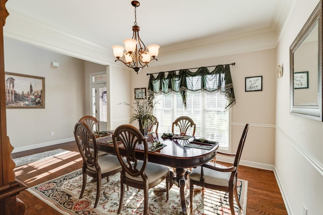 dining area featuring dark wood-type flooring, crown molding, and a chandelier