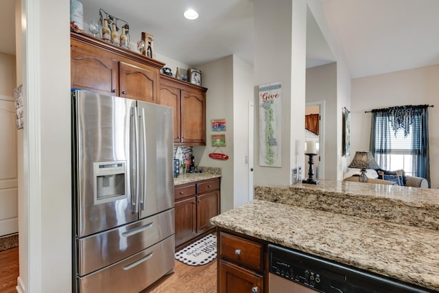 kitchen featuring light hardwood / wood-style floors, light stone countertops, and stainless steel appliances