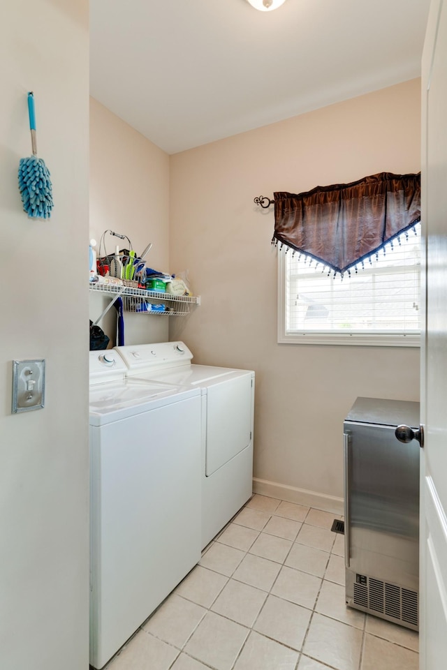 clothes washing area featuring independent washer and dryer and light tile patterned flooring