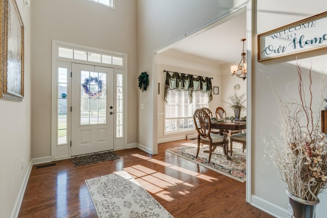 foyer with plenty of natural light, dark hardwood / wood-style flooring, and a notable chandelier