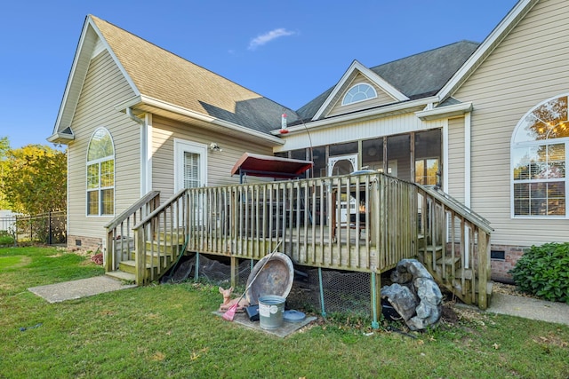 back of house with a wooden deck, a sunroom, and a lawn