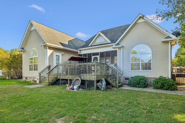 back of property with a lawn, a wooden deck, and a sunroom