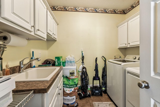 washroom with sink, washing machine and dryer, light tile patterned floors, and cabinets